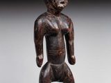 an image of a wooden statue of a man standing on a base