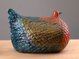 un poulet en céramique aux couleurs vives posé sur une table en bois