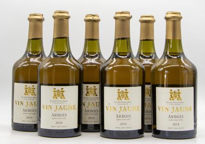 six bottles of wine are lined up in a row on a white surface