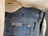the back of a person wearing a white shirt and blue jeans