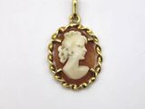 a gold pendant with an image of a woman in profile