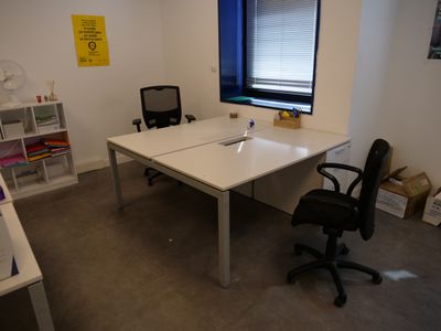 a white desk with a black chair and a window
