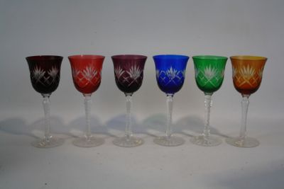 six verres à vin sont alignés sur une surface blanche