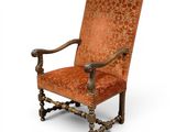 un fauteuil rembourré de couleur orange, doté d'une structure en bois et d'une assise rembourrée richement décorée