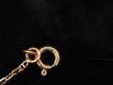 a close up of a gold chain with a lock on a black background