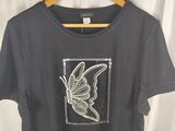 the shirt is on a hanger with a white curtain behind it