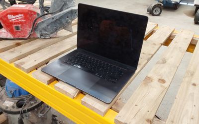 un ordinateur portable posé sur une palette dans un entrepôt