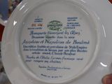 someone is holding a plate with a picture on it in front of a red table