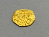 a close up of a gold coin on a gray surface