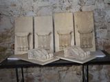 trois œuvres d'art posées sur une table devant un mur de briques