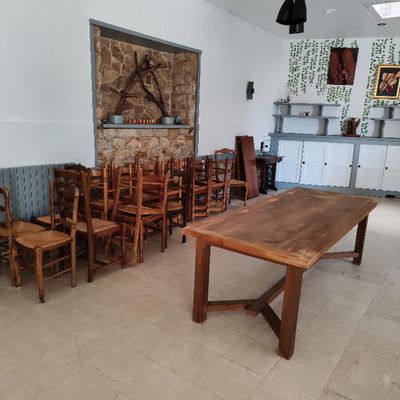 des tables et des chaises dans une pièce avec un mur en pierre en arrière-plan