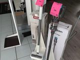two vacuums that are on the floor in front of a window