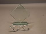 un petit trophée en verre posé sur un socle, sur une table