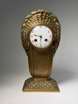 a gold clock with a face made of grapes on it