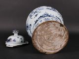 a blue and white vase sitting next to a small white cup