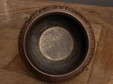 a small metal bowl sitting on a wooden table