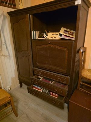 une armoire en bois sur laquelle sont posés des livres, dans un coin de la pièce