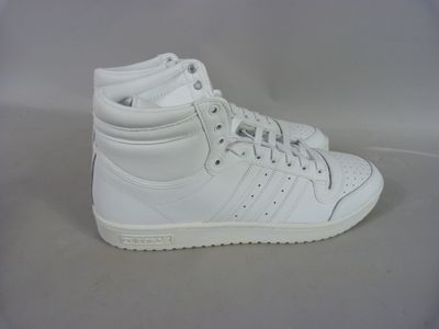 white adidas sneakers on a white surface with a white background