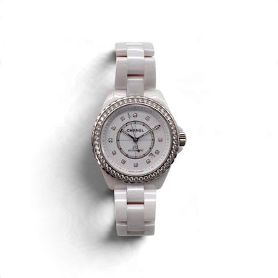 une image représentant une montre blanche sertie de diamants sur un fond blanc