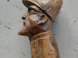une statue en bois d'un homme avec un chapeau sur la tête