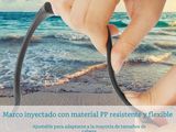a person holding a pair of scissors on the beach