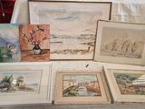 de nombreux tableaux exposés sur une table dans une pièce