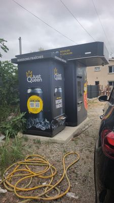 une voiture noire garée devant une station-service
