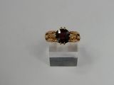 a close up of a gold ring with a garnetite stone