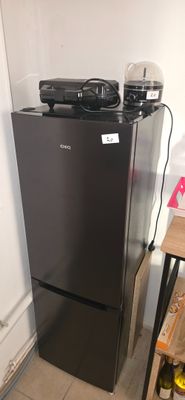 a black refrigerator in the corner of a kitchen