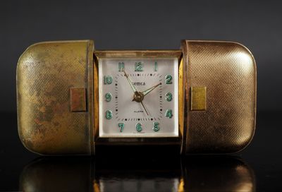 a gold case with a clock inside of it on a table
