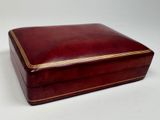 a red leather box with gold trimming on the sides