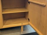 a wooden cabinet with a door open on the floor