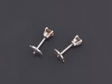 a pair of silver stud earrings on a black surface