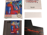 a box of game cartridges and a book on a table