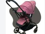 pink baby stroller with black handlebars and black wheels