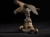 une statue d'aigle sur un socle, sur fond noir