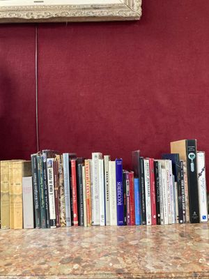 de nombreux livres posés sur une table devant un tableau