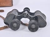 a pair of binoculars sitting on a table next to a piece of luggage