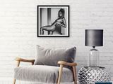 black and white photograph of a woman sitting in a chair next to a lamp