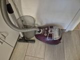un aspirateur posé sur le sol à côté d'une poubelle