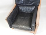 a black leather chair with a wooden frame on a white background