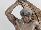 statue of a man with a sword and wings on a pedestal