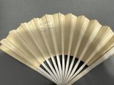 a white fan with writing on it sitting on a table