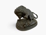 bronze statue of a lion on a rock on a white background