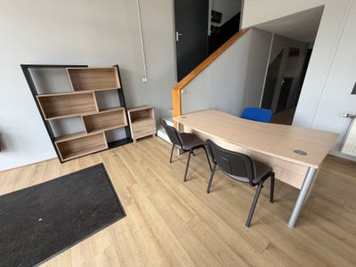 une table et des chaises dans une pièce où se trouve une bibliothèque