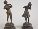 paire de figurines en bronze représentant un homme et une femme jouant de la flûte