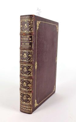 un vieux livre marron avec des bordures dorées et une couverture aux bordures dorées