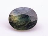 a close up of a green and black stone on a white surface