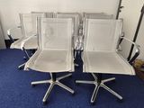 four white office chairs sitting on top of a blue carpet