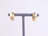 a close up of a pair of gold earrings on a stand